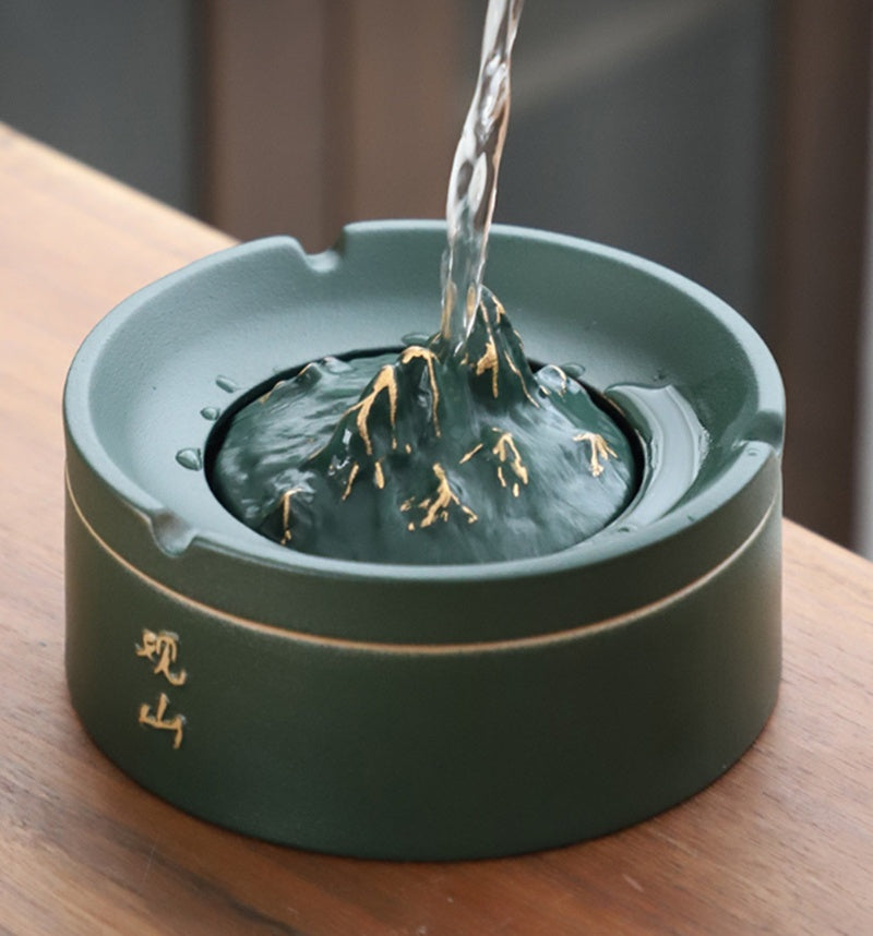 Green ceramic container with water being poured into it on a wooden surface